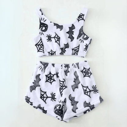 Flat lay of halloween white spiderweb sherpa pajama set with crop top and shorts on white background