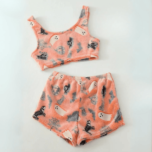 Flat lay of pink halloween ghost-print sherpa pajama set with crop top and shorts on white background